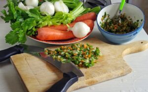 Brodo di carne caldo in pentola, con verdure fresche e aromi, pronto per un sapore ricco e avvolgente.