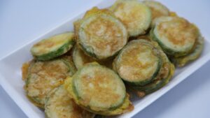 Zucchine trifolate dorate in padella, pronte da servire, salate solo alla fine della cottura.