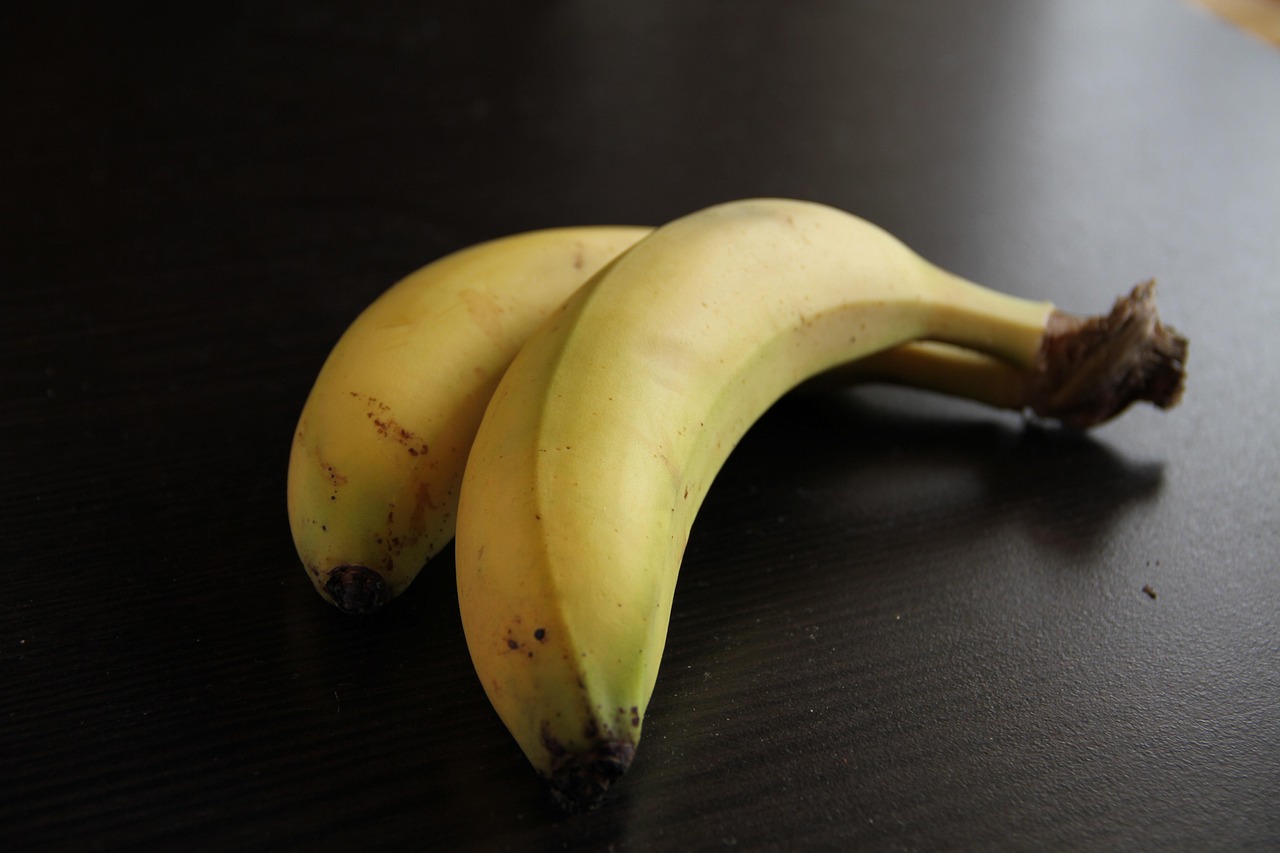 Banane con il picciolo avvolto in pellicola trasparente per conservarle più a lungo.