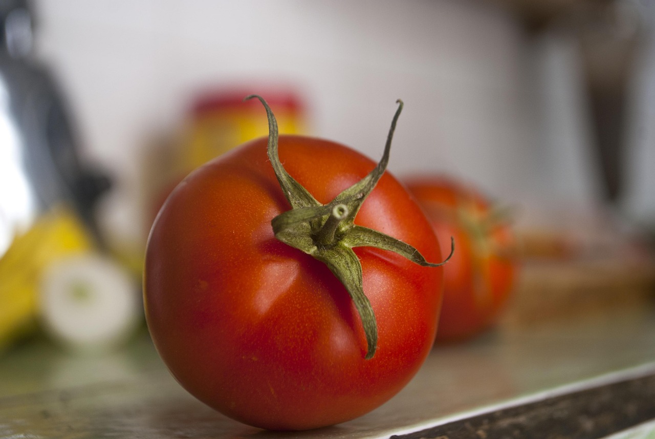Pomodori freschi su un piano di legno, evidenziando la loro brillantezza e freschezza, lontano dal frigo.