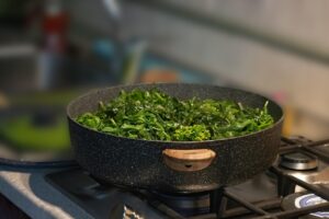 Cime di rapa fresche in padella, pronte per essere sbollentate e cucinate per un piatto saporito.